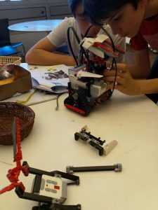 Image of two young white boys building a robot together